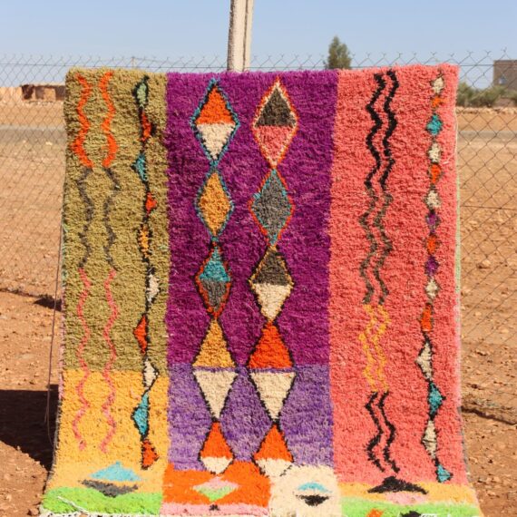 Handwoven colorful rug with vibrant abstract design, featuring bright patterns.