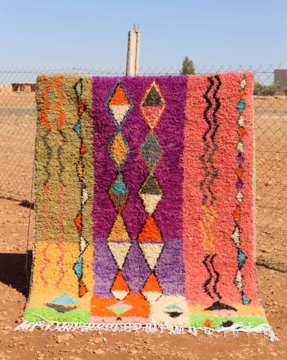 Handwoven colorful rug with vibrant abstract design, featuring bright patterns.