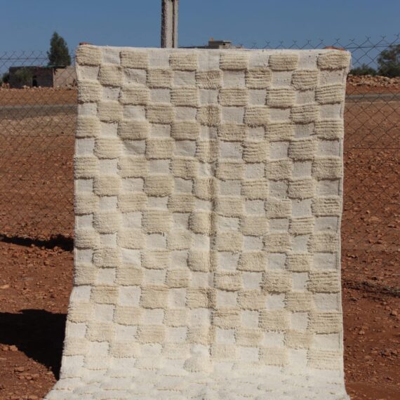 Handwoven white wool rug featuring a classic Moroccan checkered design.