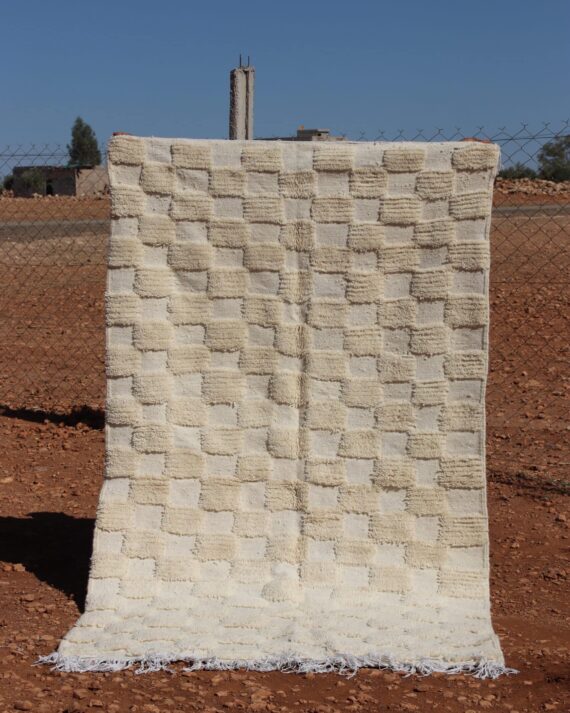 Handwoven white wool rug featuring a classic Moroccan checkered design.