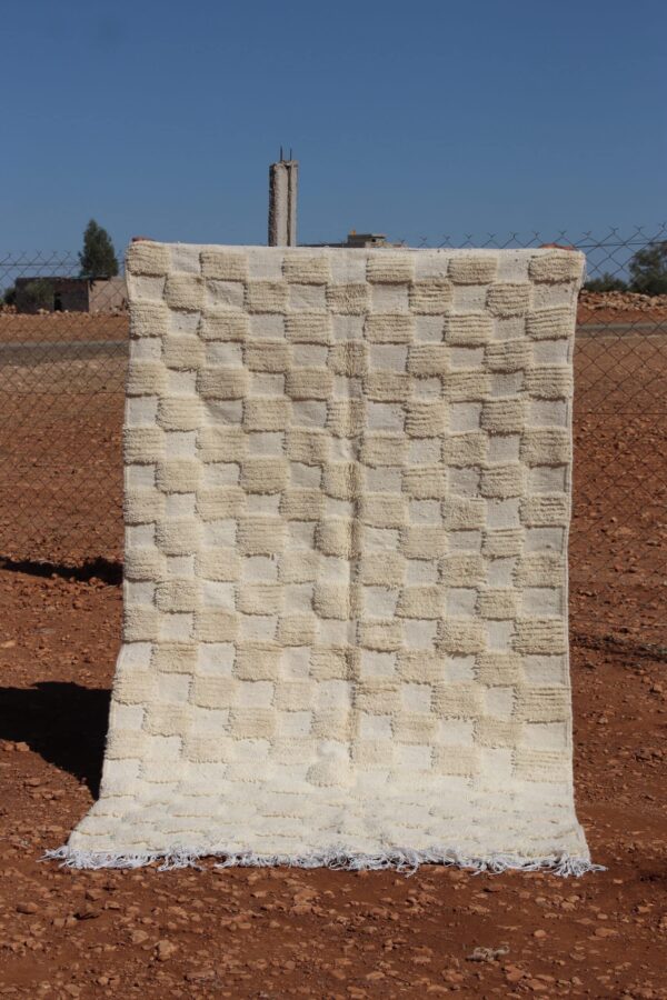 Handwoven white wool rug featuring a classic Moroccan checkered design.